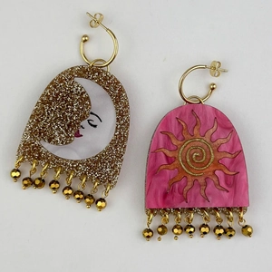 Asymmetric gold earrings featuring moon and sun motifs with elegant beaded tassels