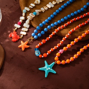 Colorful ocean themed beaded necklaces with starfish and crab pendants on velvet