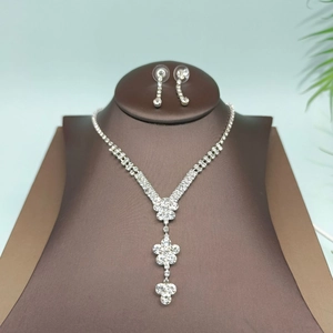 Conjunto de collar y pendientes de cristal plateado en un soporte de cuero marrón