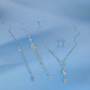 Detalle de conjunto de joyería plateada con cristales, collar en V y pendientes largos