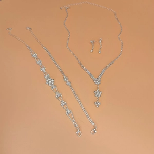 Detalle del conjunto de joyas plateadas con collar, pendientes y pulseras brillantes