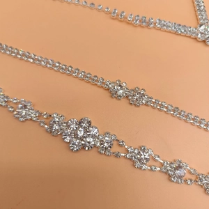 Primer plano de un conjunto de joyas con pedrería brillante sobre fondo rosa
