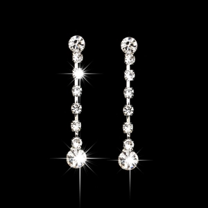 Detalle de pendientes largos de cristal plateado con piedras brillantes sobre un fondo negro