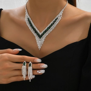 Macro detail of luxury silver necklace set with green marquise stones and crystal fringes