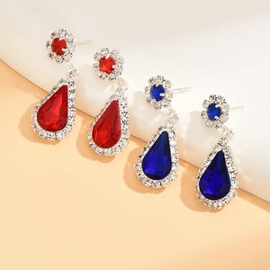 Close-up of red and blue crystal teardrop earrings with floral studs and micro-pave crystals