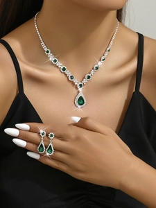 Detailed view of emerald green pear-cut crystal necklace and earrings set on model