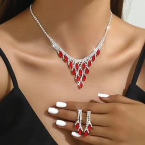 Primer plano de conjunto de joyas nupciales con cristales rojos y acabado en plata fina