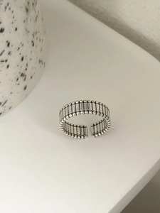 Close-up of vintage S925 sterling silver ring featuring vertical stripes and gear texture