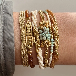 Bohemian gold layered bracelet set with turquoise beads and ivory pearls on a wrist