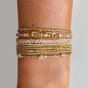 Macro detail of bohemian layered bracelet set with turquoise and gold beaded textures