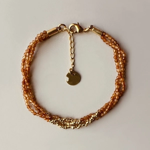 Close-up of triple-layer turquoise and amber beaded bracelet with gold lobster clasp