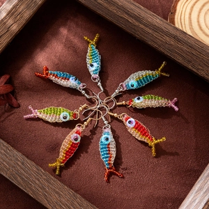 Top view of handmade colorful beaded fish earrings arranged in a circle on brown velvet