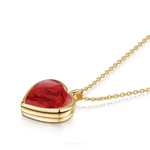 Vista macro del colgante de corazón de oro 18k con incrustación de esmalte rojo marmoleado