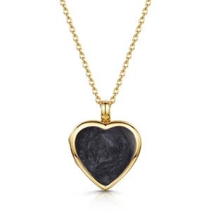 Vista macro de relicario de corazón en oro 18k con esmalte negro brillante y cadena fina