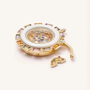 Dettaglio di medaglione vintage con pietre colorate e struttura meccanica girevole