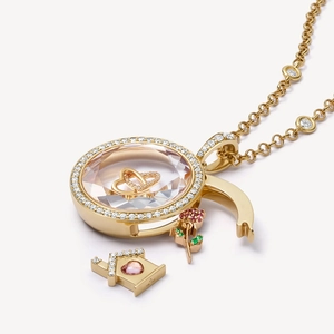 Macro del ciondolo in oro 18K con cristallo sfaccettato e dettagli di ciondoli rosa