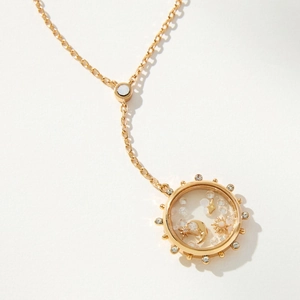 Détail du médaillon en or 18k avec breloques célestes de lune et d'étoiles