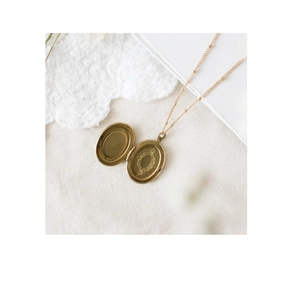 Detail eines Vintage 14k Gold Medaillon Anhängers mit Gravur und eleganter Kugelkette