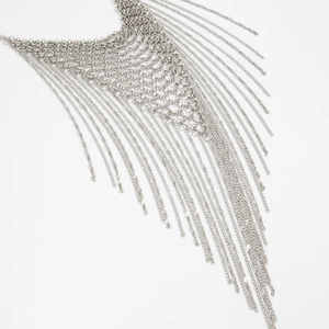 Detail of silver layered chain fringe necklace with mesh structure and woven tassels