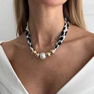 Detailopname van luipaardprint stoffen ketting met centrale parel en gouden kralen