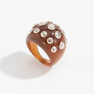 Macro view of wide resin ring with amber dome finish and silver metallic stud accents