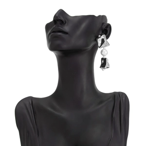 Détail de boucles d'oreilles argentées géométriques avec perles et carrés irréguliers