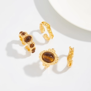 Detail von vierteiligem Vintage-Goldring-Set mit Tigerauge-Steinen und Lava-Textur