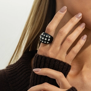 Close-up of a bold black resin wide ring featuring inlaid sparkling rhinestones