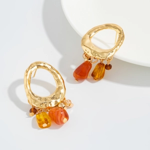 Close-up of bohemian irregular amber resin beads on vintage gold flower earrings