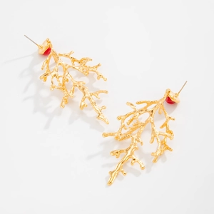 Detailed close-up of golden branch-shaped earrings with delicate red resin beads