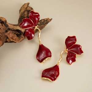 Detail view of long vintage red flower drop earrings with golden wavy metal stems