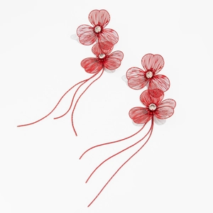 Detailed view of red floral tassel earrings with metal petals and sparkling crystals
