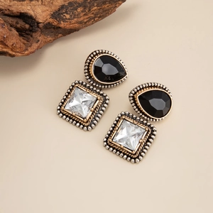 Détail de boucles d'oreilles baroques avec pierres noires en goutte et cristaux