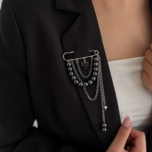 Silver fringe brooch with dark crystal beads and black heart pendant on a black blazer