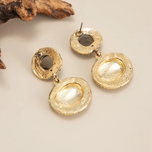 Vue détaillée de boucles d'oreilles dorées vintage montrant le fini texturé et le clou