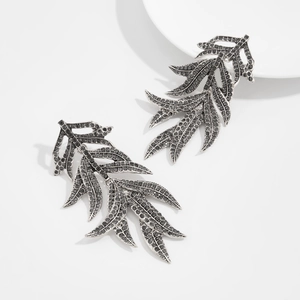 Détail de boucles d'oreilles feuilles en argent vintage avec cristaux gris foncés
