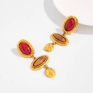Details von Vintage-Goldohrringen mit rotem Marmorharz und strukturierten Tropfen