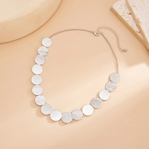 Detail view of silver geometric discs necklace with brushed texture and lobster clasp