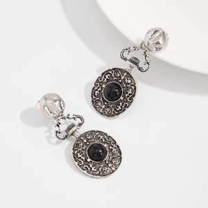 Détail des boucles d'oreilles de style cour rétro avec filigrane argent et pierre noire
