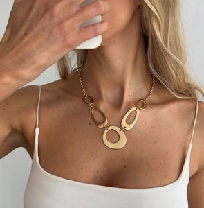 Detailed view of golden irregular geometric hollow pendants on a sleek metal waist chain