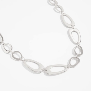 Close-up of silver metal waist chain with hollow round links and minimalist geometric design