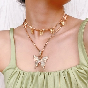 Detail of layered gold choker and butterfly pendant necklace with sparkling rhinestones
