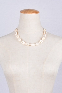 Détail du collier de coquillages bohème avec des coquillages beiges sur présentoir