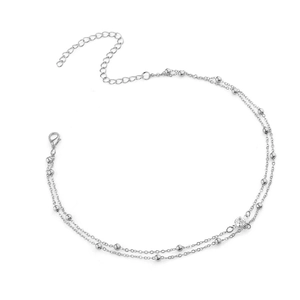 Dettaglio della collana a doppio strato argento con piccole perline e ciondolo di cristallo