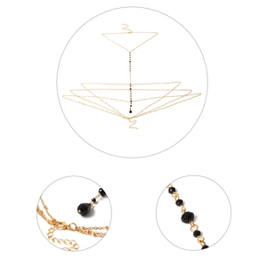 Détails de la chaîne de corps dorée avec perles noires et pendentif en cristal goutte