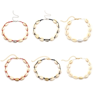 Detail view of handmade cowrie shell necklaces with colorful woven cords and metal clasps