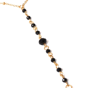 Détail d'une chaîne de corps sexy avec maillons dorés et perles de cristal noir facettées