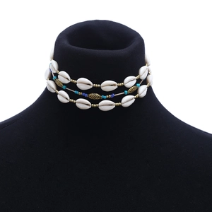 Detail of three-layer shell choker with turquoise beads and gold vintage charms