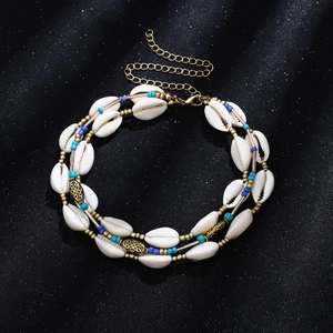 Detail of bohemian double-layered choker with blue beads, white shells and gold accents