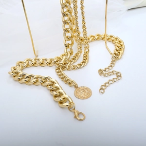 Detail einer mehrlagigen goldenen Taillenkette mit Vintage-Münze und Karabinerverschluss